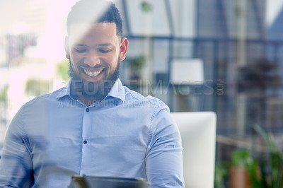 Buy stock photo Cropped shot of a handsome young businessman sitting alone in his office and using a digital tablet