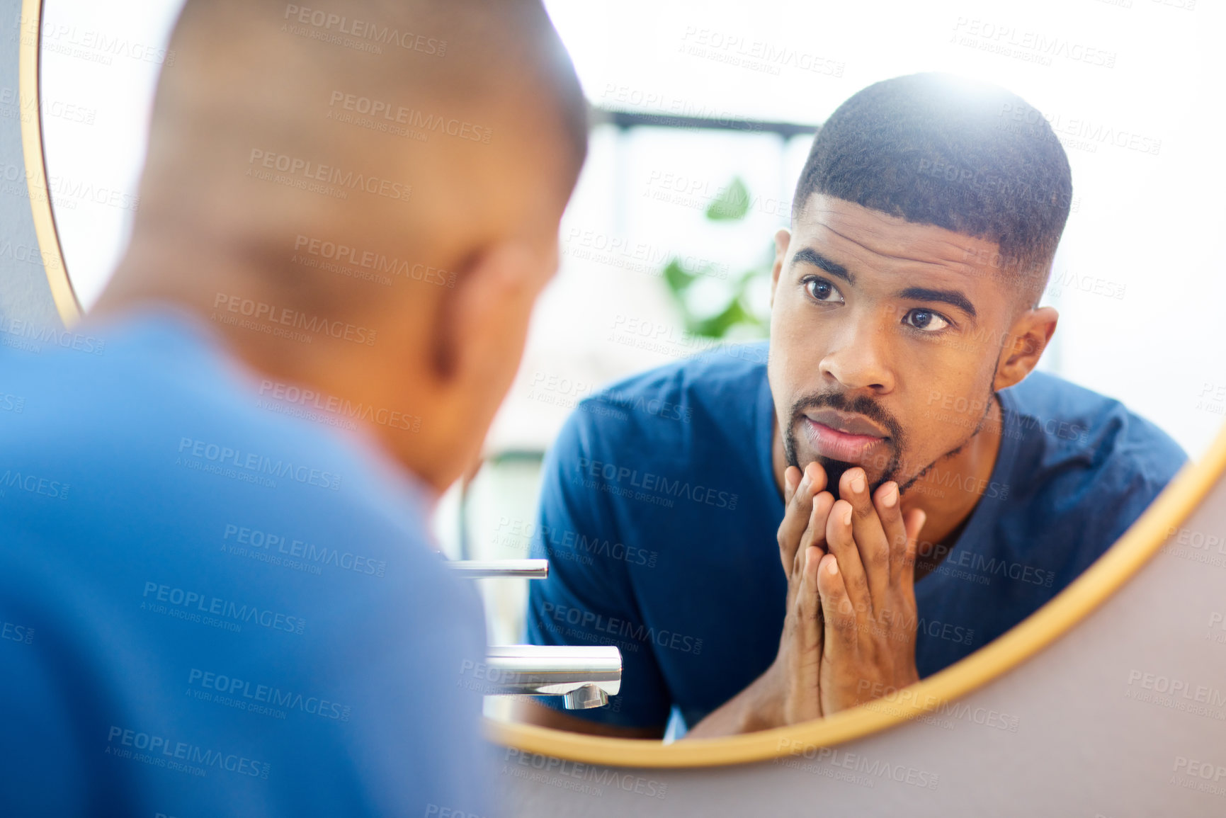 Buy stock photo Shot of young man admiring his face in his bathroom mirror