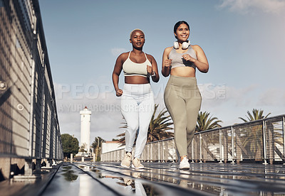 Buy stock photo Shot of two young women out for a run together