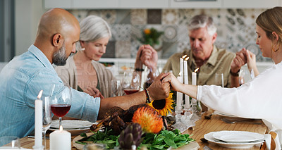 Buy stock photo Shot of two couples sitting down for lunch and praying at home