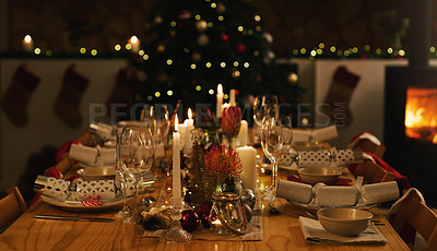 Buy stock photo Dinner, table and Christmas in home with candles at night, love and celebration for holidays. Feast, dining and house or dark with lights for xmas, flowers and bowls or wine glasses at fireplace