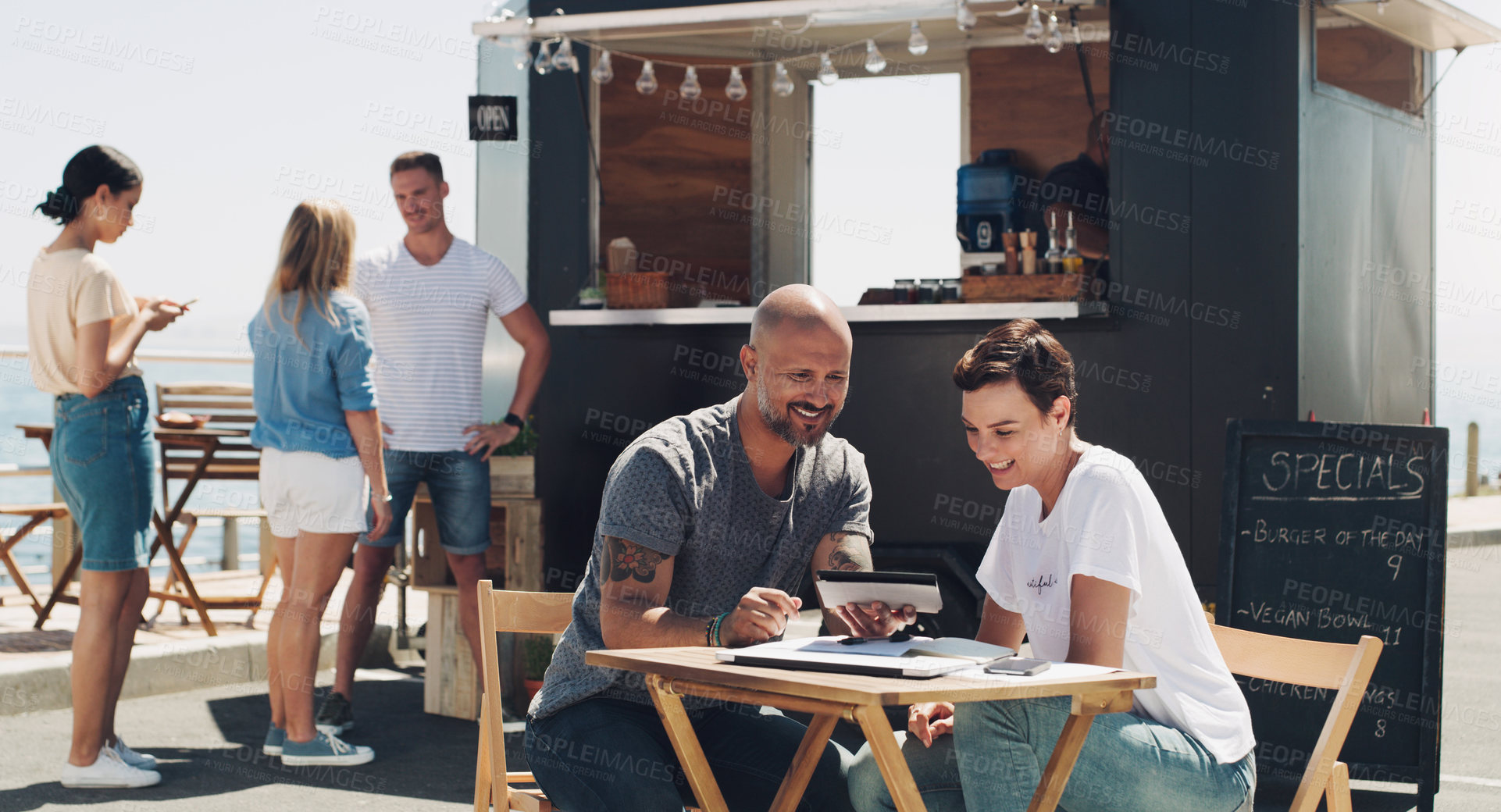 Buy stock photo Teamwork, meeting and small business owners with tablet at food truck for conversation, planning or discussion on menu. Restaurant, happy man and employee woman for collaboration, startup or talking