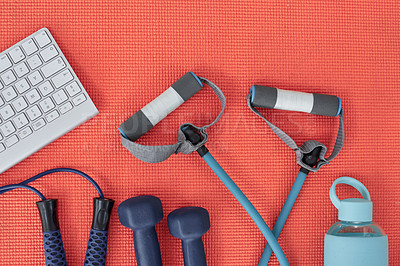 Buy stock photo Studio shot of a variety of workout equipment and a keyboard on a red yoga mat