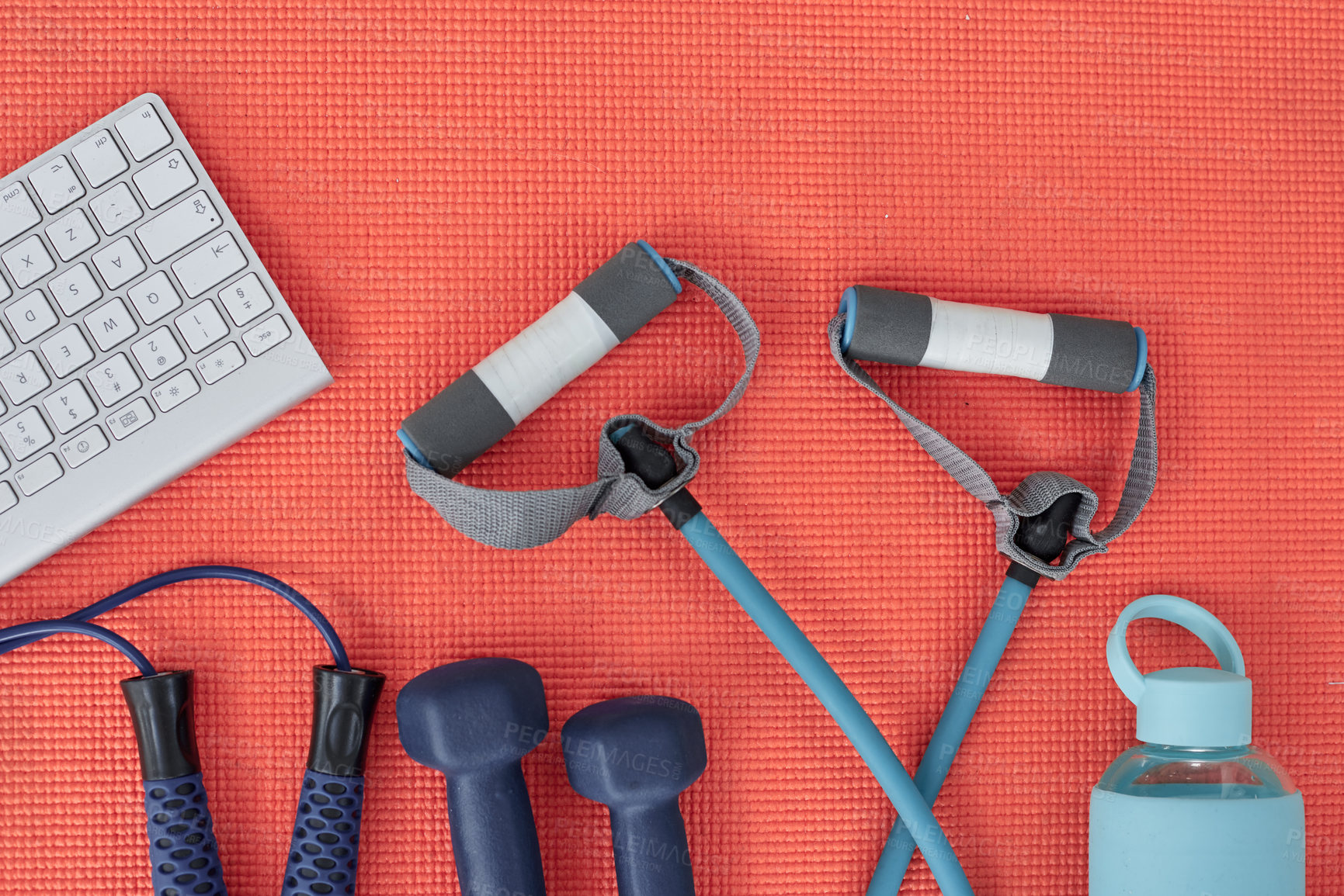 Buy stock photo Studio shot of a variety of workout equipment and a keyboard on a red yoga mat