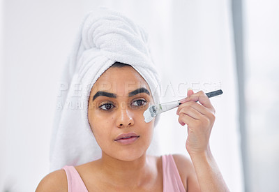 Buy stock photo Shot of a woman using a paintbrush to apply a product to her face