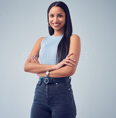 Buy stock photo Cropped portrait of an attractive young woman standing with her arms crossed against a grey background in studio