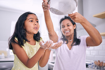 Buy stock photo Cropped shot of an adorable little girl baking at home with her mother