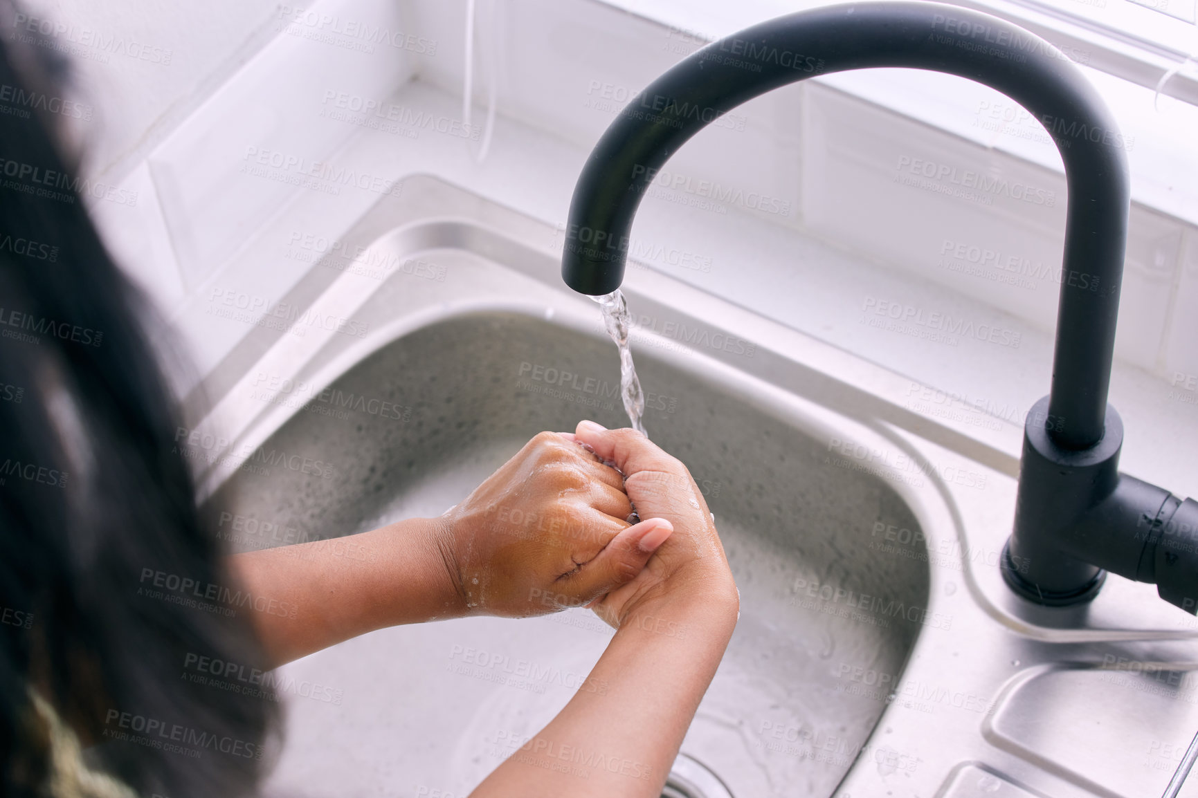 Buy stock photo Cropped shot of an unrecognizable girl washing her hands by the kitchen sink