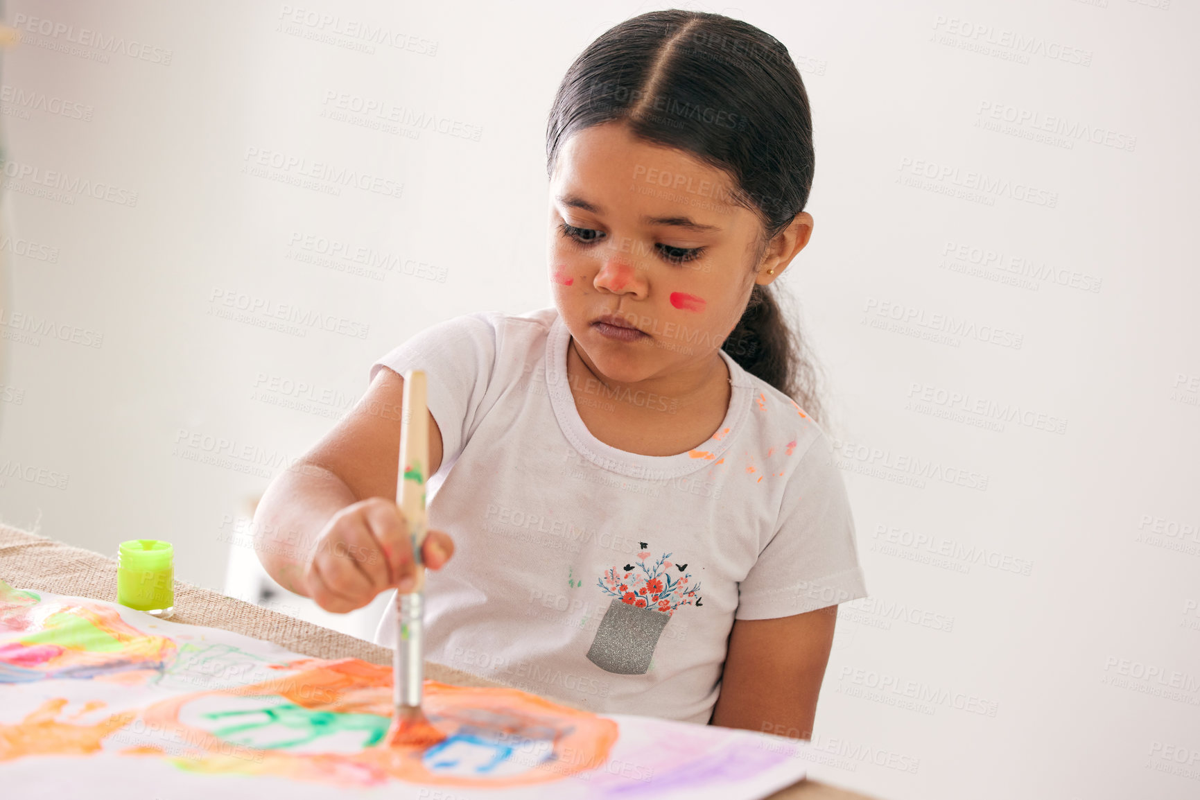 Buy stock photo Shot of an adorable little girl painting while sitting at a table