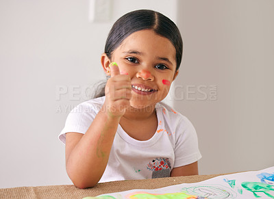 Buy stock photo Shot of an adorable little girl showing thumbs up while painting