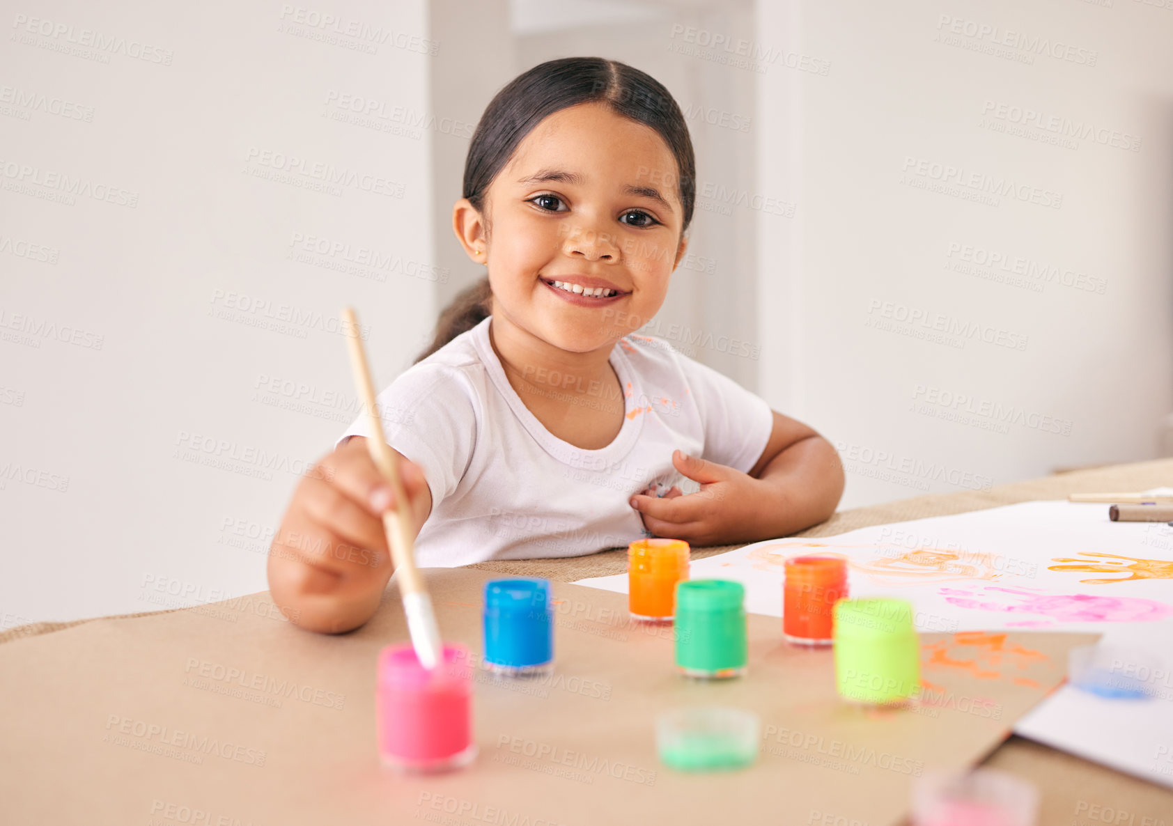 Buy stock photo Shot of an adorable little girl painting while sitting at a table