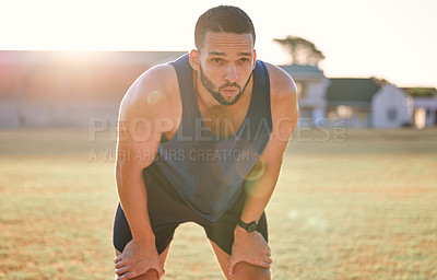 Buy stock photo Man, tired and breathing outdoor with fitness for exercise break, workout and training on sports field. Athlete, person and runner with relax, overworked and healthy body with wellness on stadium
