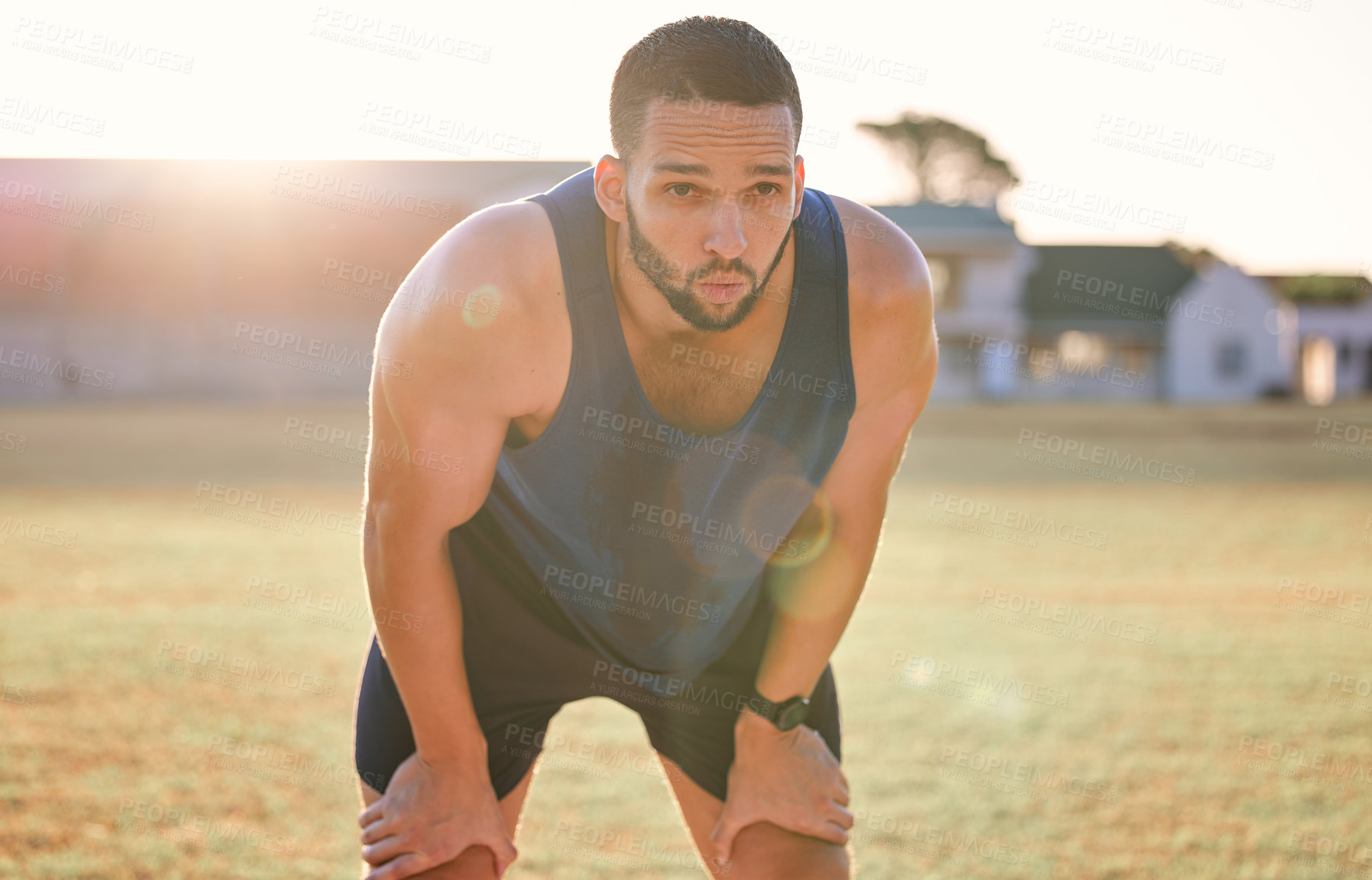 Buy stock photo Man, tired and breathing outdoor with fitness for exercise break, workout and training on sports field. Athlete, person and runner with relax, overworked and healthy body with wellness on stadium