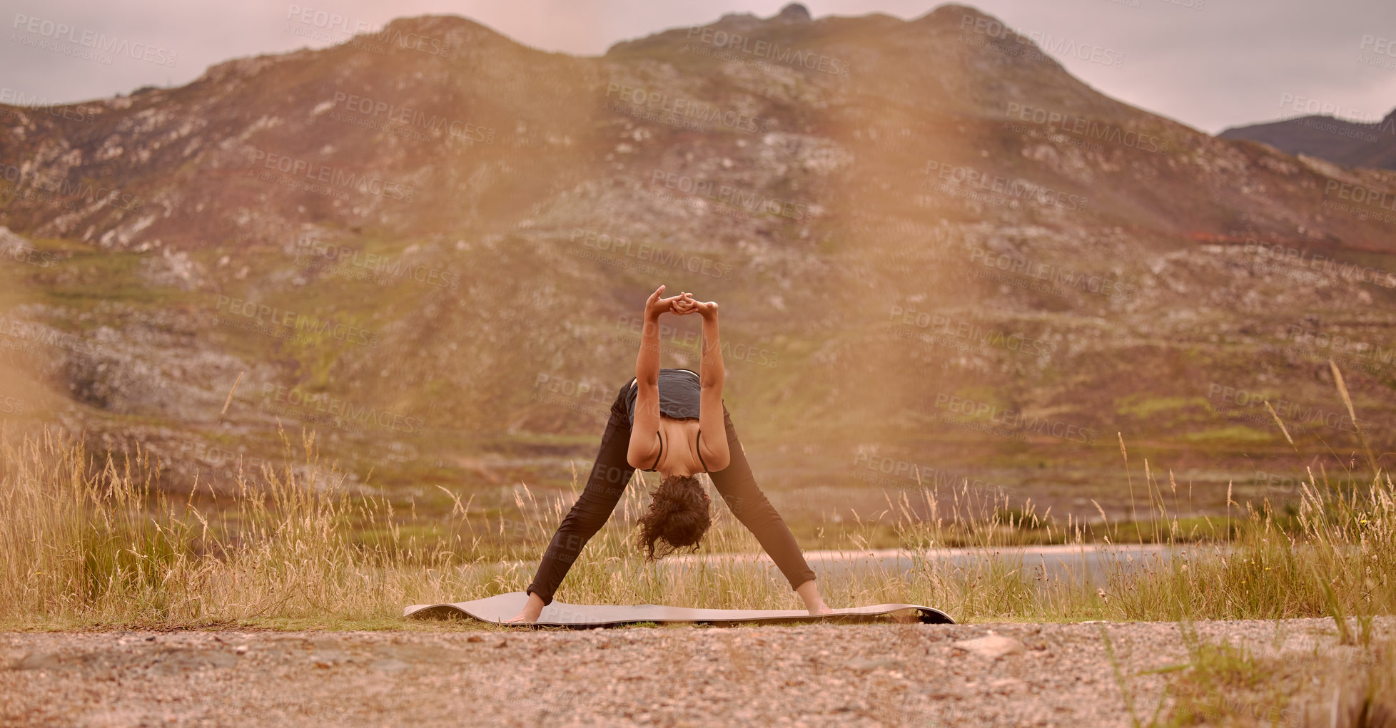 Buy stock photo Yoga, woman and stretching outdoor for fitness, wellness and mindfulness on mountain. Sunset, zen chakra and calm female yogi practicing pilates, balance and training, for health and wellbeing