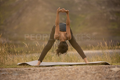 Buy stock photo Shot of a young woman practising yoga outdoors