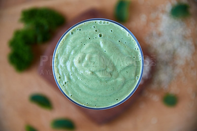 Buy stock photo Overhead shot of a green health smoothie on a wooden board