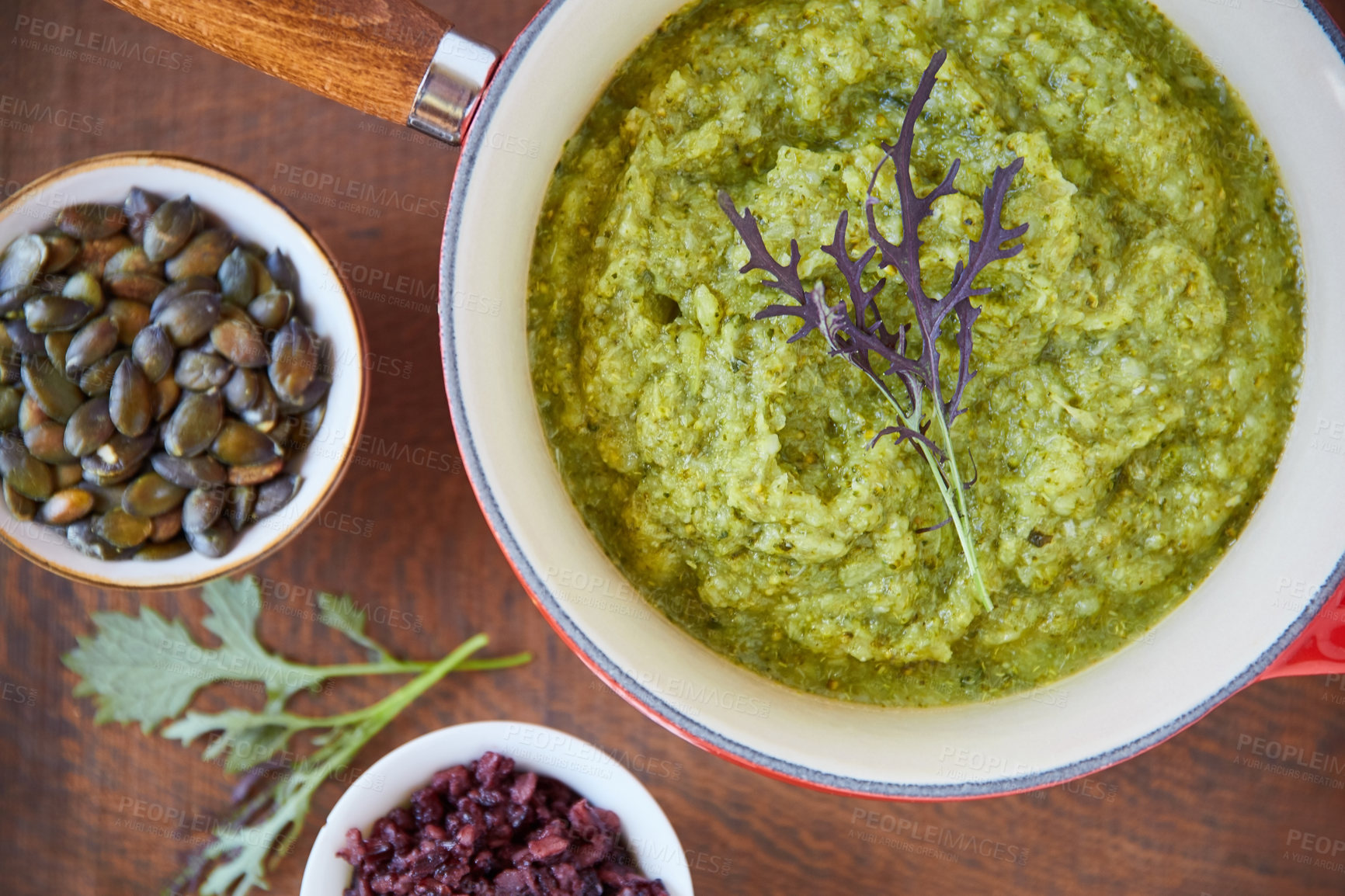 Buy stock photo Above, guacamole and pumpkin seeds on table with healthy food, meal preparation and vegan nutrition. Plant based, cuisine and avocado dip in pan with garnish, organic dish or green sauce for wellness