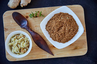 Buy stock photo Overhead shot of a ramekin of fresh chopped ginger and grain powder on a wooden board