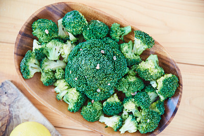 Buy stock photo Overhead shot of raw broccoli in a wooden serving bowl on a wooden table