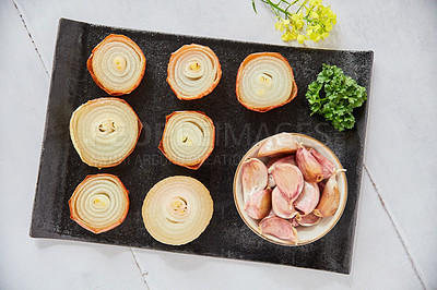 Buy stock photo Overhead shot of roasted onions on a black serving plate