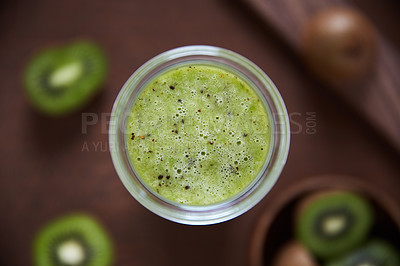 Buy stock photo Overhead shot of a kiwi smoothie on a wooden board