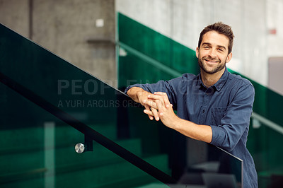 Buy stock photo Cropped portrait of a handsome young businessman standing alone and leaning on a staircase outdoors alone