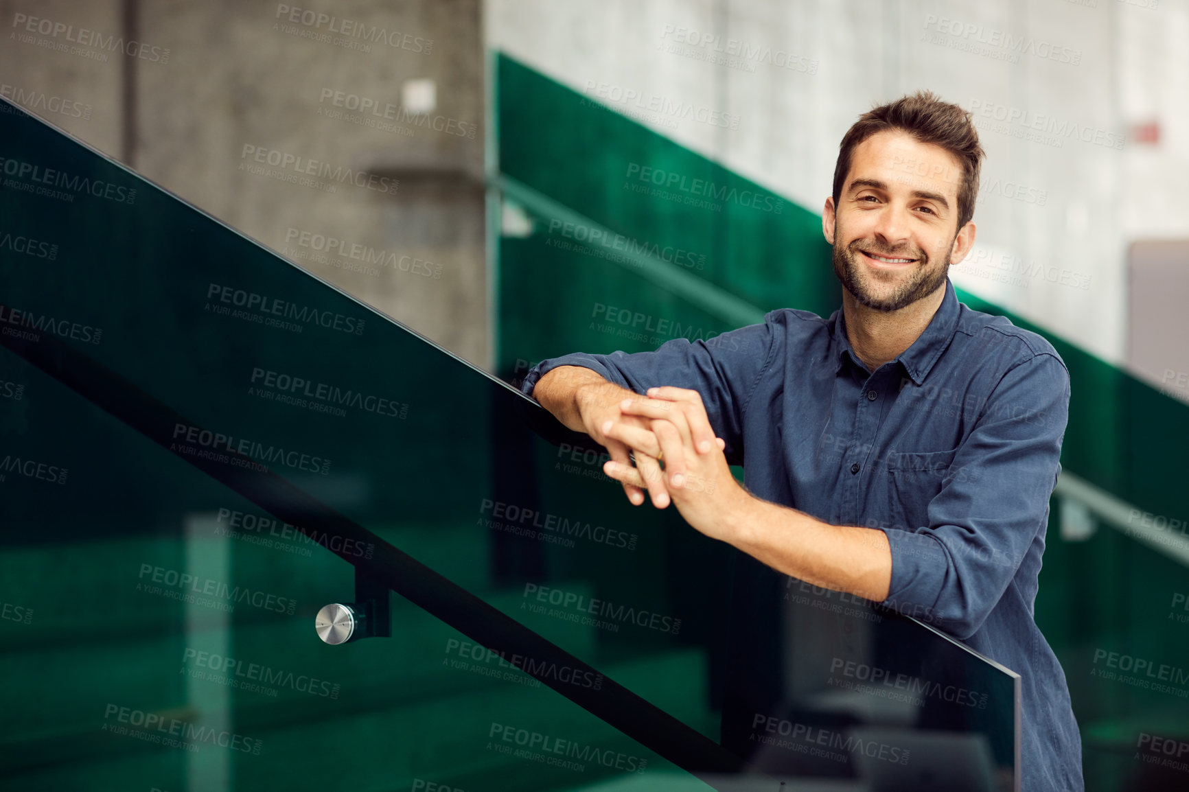 Buy stock photo Cropped portrait of a handsome young businessman standing alone and leaning on a staircase outdoors alone
