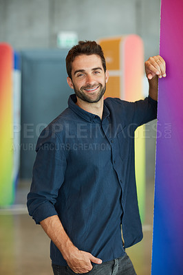 Buy stock photo Cropped portrait of a handsome young businessman standing alone in an office space during the day