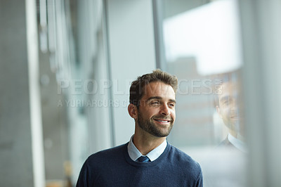 Buy stock photo Cropped shot of a handsome young businessman standing indoors alone during the day