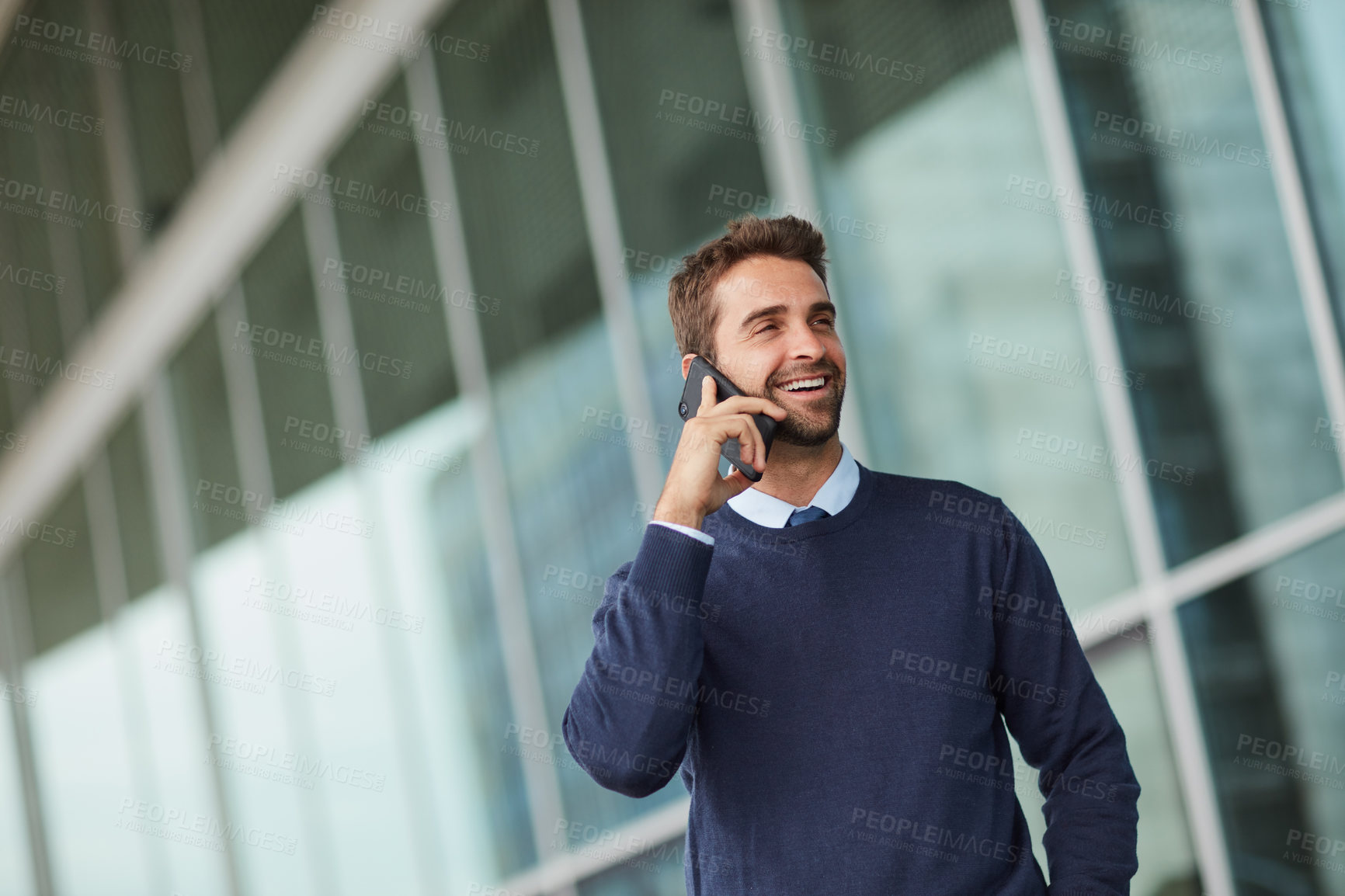 Buy stock photo Cropped shot of a handsome young businessman standing alone outside and using his cellphone during the day