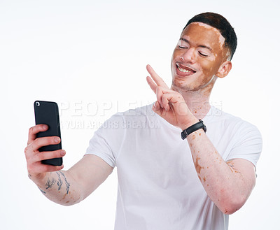 Buy stock photo Happy man, vitiligo and selfie with peace sign for memory, picture or photography on a white studio background. Young or handsome male person with smile or emoji for capture, moment or social media