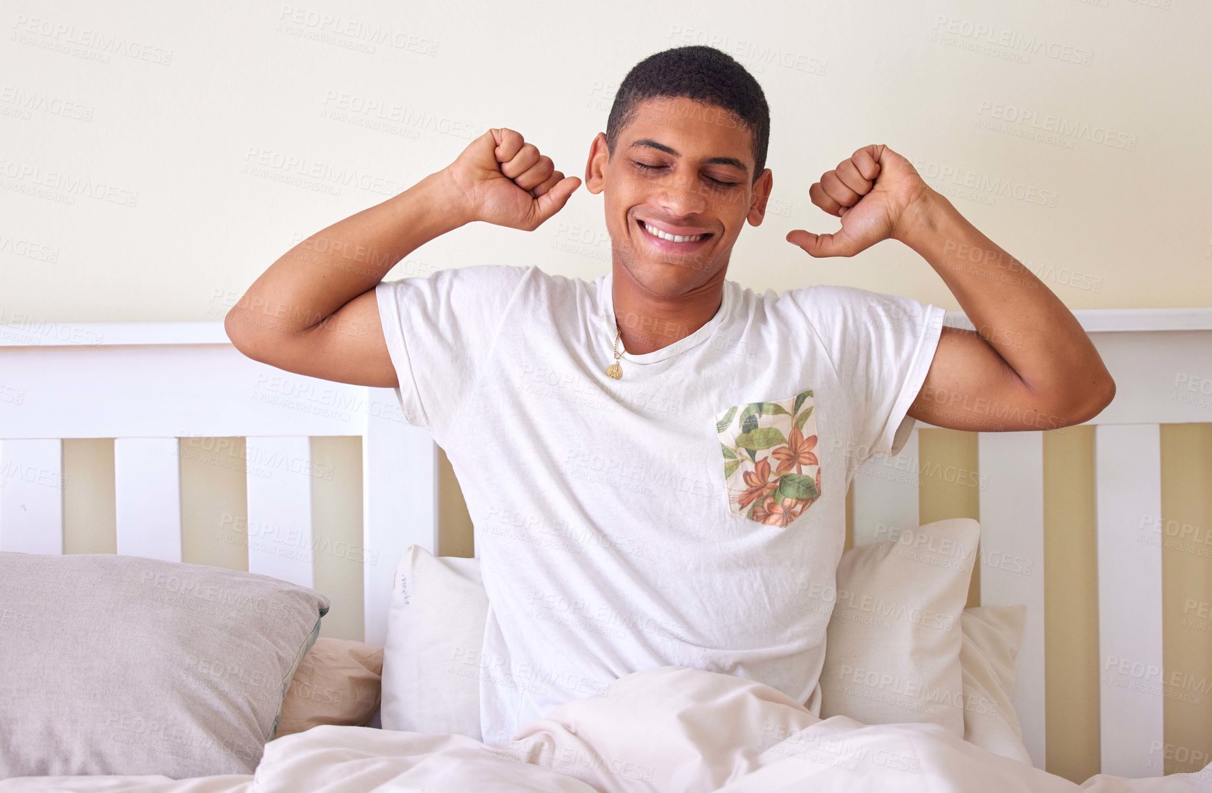 Buy stock photo Cropped shot of a handsome young man sitting up in bed and stretching during the early hours of the morning