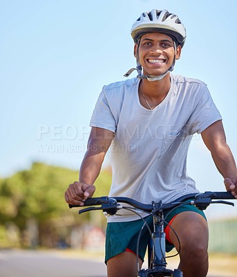 Buy stock photo Shot of a young man riding his bike in nature