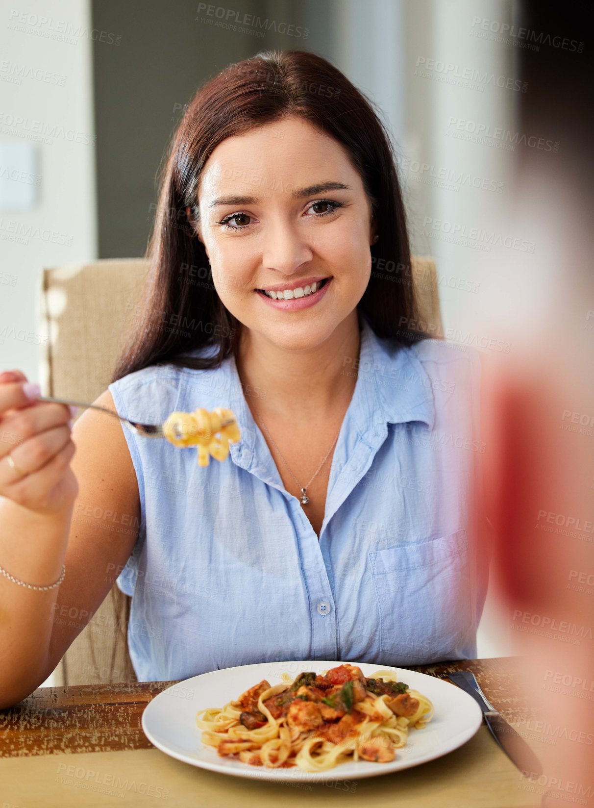 Buy stock photo Shot of a young woman sitting down to eat at home