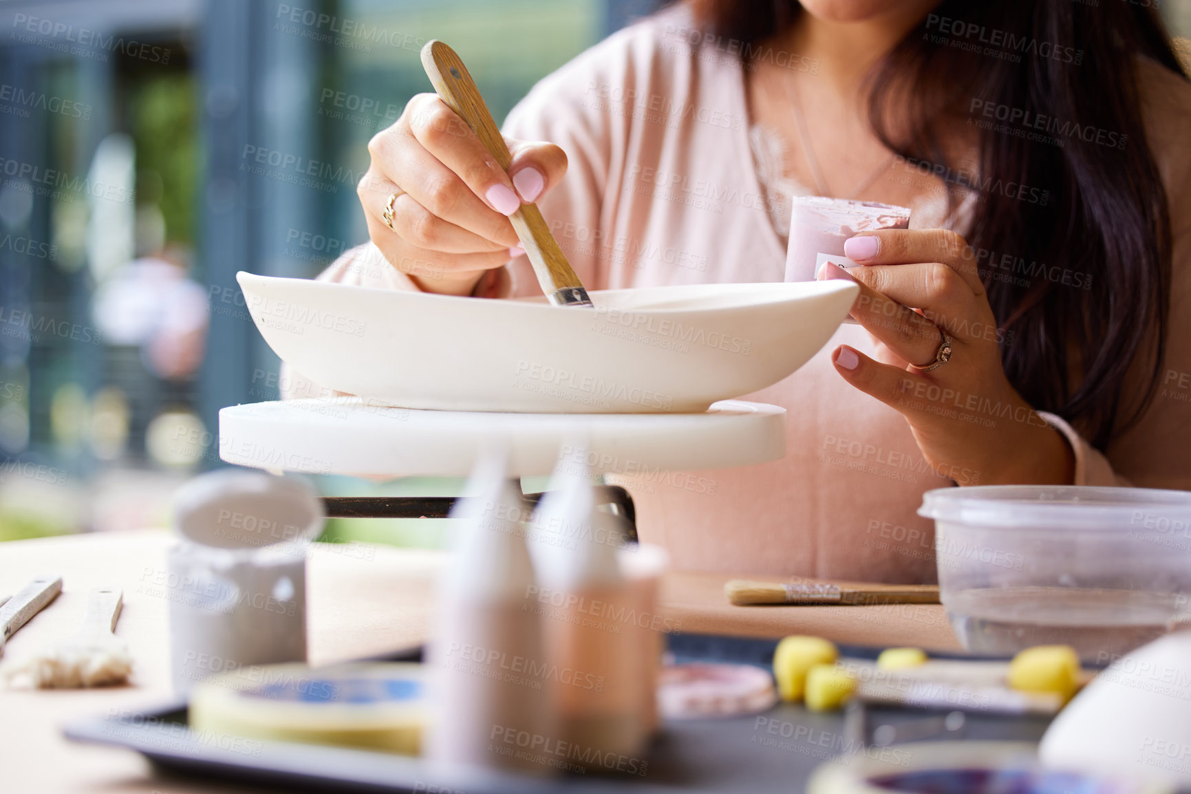 Buy stock photo Cropped shot of a young woman painting ceramics in an art studio