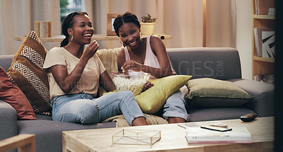 Buy stock photo Shot of two friends relaxing and hanging out on the couch at home