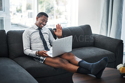 Buy stock photo Full length shot of a handsome young businessman sitting alone on the sofa in his boxers and working from home