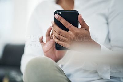 Buy stock photo Cropped shot of an unrecognizable businesswoman sitting alone and using her cellphone at home