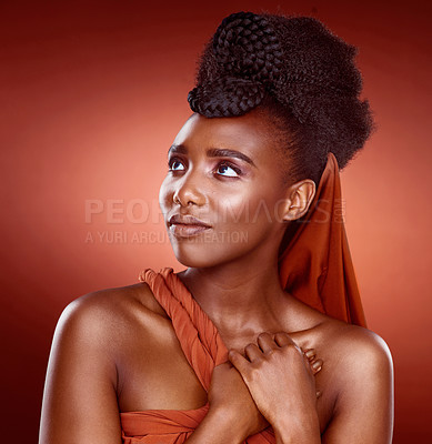 Buy stock photo Black woman, thinking and beauty with makeup in fashion for facial cosmetics on a red studio background. Young African, female person or attractive model with traditional clothing, care or pride