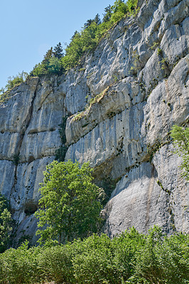 Buy stock photo Landscape view of a steep, majestic and rocky mountain cliff on a clear day during summer. Closeup of rocks on a natural mountainside slope. Explore the valley and peak while on a nature adventure