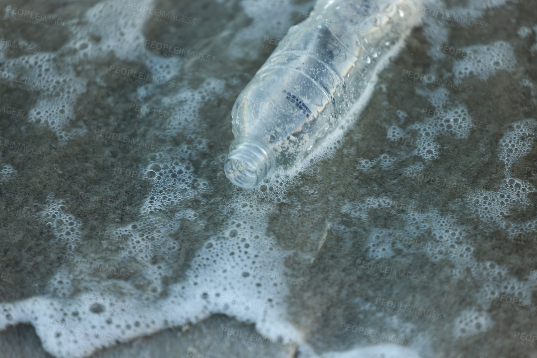 Buy stock photo Shot of a bottle laying on the beach