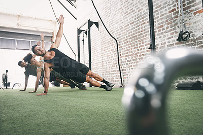 Buy stock photo Shot of a fitness group doing the side plank together at the gym