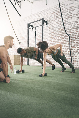 Buy stock photo Shot of two people working out with a fitness instructor at the gym