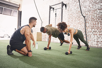 Buy stock photo Shot of two people working out with a fitness instructor at the gym