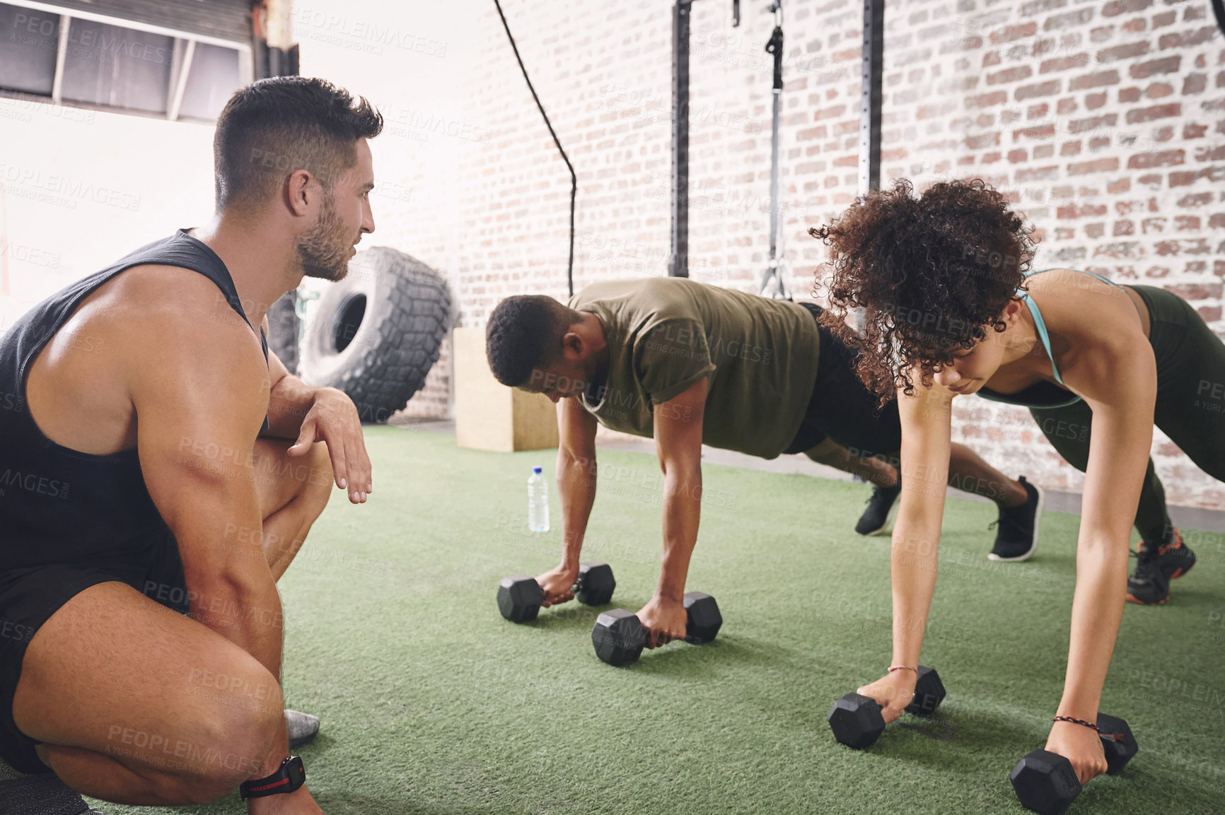 Buy stock photo Push up, dumbbells and group of people in gym for workout, training or wellness with routine. Trainer, weights and athletes with exercise for muscle strength with active or challenge in sports center