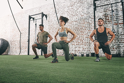 Buy stock photo Shot of a fitness group doing lunges while working out at the gym
