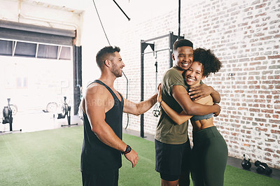 Buy stock photo Shot of three sporty young people looking cheerful at the gym