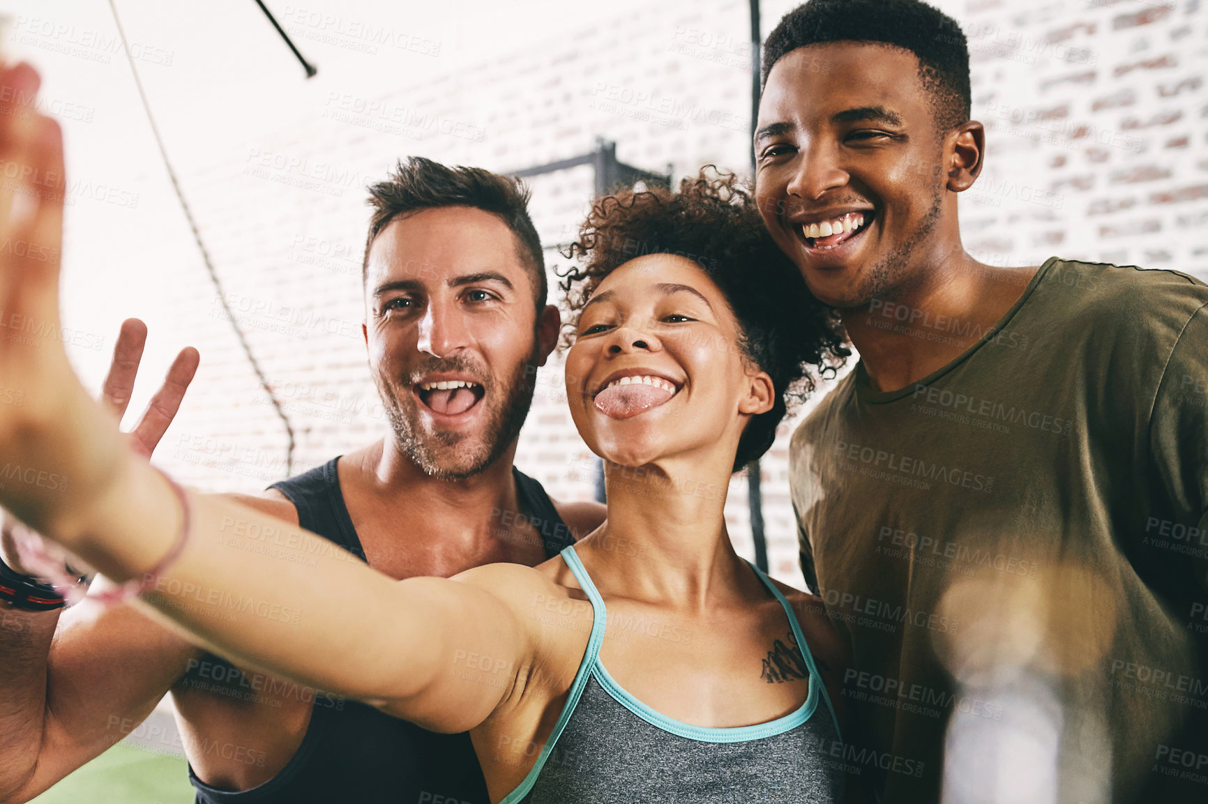 Buy stock photo Cropped shot of three sporty young people taking a selfie at the gym