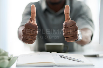 Buy stock photo Cropped shot of a young man showing thumbs up at work