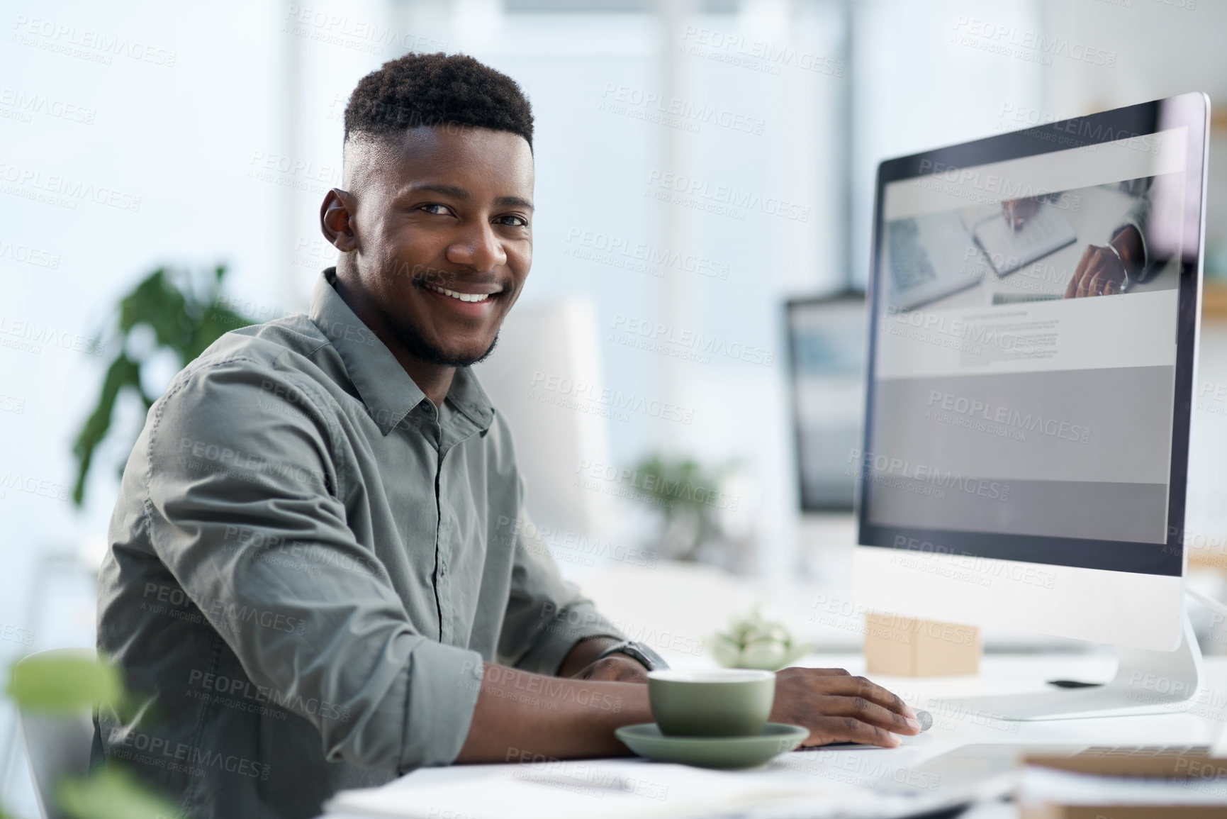 Buy stock photo Shot of a young businessman working on a computer in an office